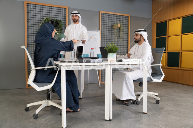 روح الفريق الواحد والعمل الجماعي، التفاهم والتعاون بين الزملاء ووضع الخطط الاستراتيجية لتحقيق الأهداف، استخدام السبورة لضمان فهم واضح وشامل للاعمال، عقد اجتماع داخل مقر الشركة، مجموعة من الموظفين العرب الخليجيين الاماراتيين يتعلمون اساليب العمل والتطوير المهني