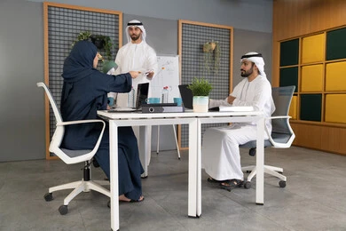 روح الفريق الواحد والعمل الجماعي، التفاهم والتعاون بين الزملاء ووضع الخطط الاستراتيجية لتحقيق الأهداف، استخدام السبورة لضمان فهم واضح وشامل للاعمال، عقد اجتماع داخل مقر الشركة، مجموعة من الموظفين العرب الخليجيين الاماراتيين يتعلمون اساليب العمل والتطوير المهني