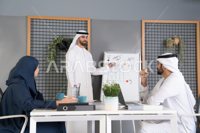 استخدام السبورة لضمان فهم واضح وشامل للاعمال، مجموعة من الموظفين العرب الخليجيين الاماراتيين يعقدون اجتماع داخل مقر الشركة، تعلم اساليب العمل والتطوير المهني، العمل الجماعي وروح الفريق، التفاهم والتعاون بين الزملاء ووضع الخطط الاستراتيجية لتحقيق الأهداف