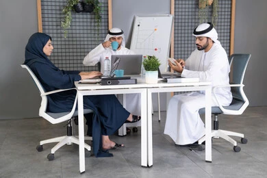 التركيز والعمل بدقة لتحقيق الاهداف، دمج العمل مع التقنية والتكنولوجيا، تطور الشركات الاماراتية، متابعة مشاريع الأعمال، مجموعة من الموظفين العرب الخلييجين الاماراتيين يقومون بإنجاز مهام العمل عبر جهاز الحاسوب داخل مقر الشركة