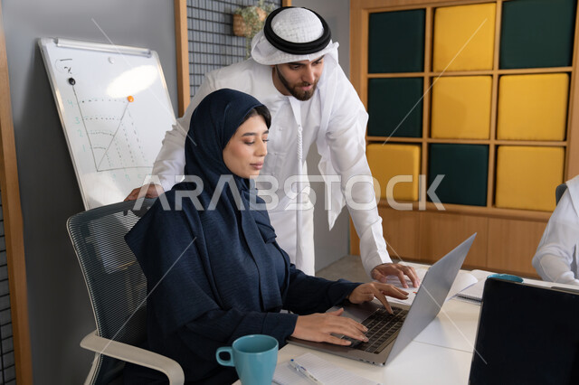 دمج العمل مع التقنية والتكنولوجيا، زميلان عربيان خليجيان اماراتيان يقومان بإنجاز المهام عبر الحاسوب المحمول، الاشارة الى اللابتوب، العمل الجماعي وروح الفريق الواحد، بيئة العمل المريحة في الامارات، تعليم الموظفين الأساليب الجديدة في العمل لتحقيق أهداف الشركة