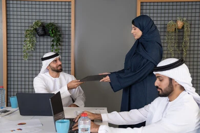 متابعة إنجازات الموظفين، الرغبة في تعلم اساليب العمل والتطوير المهني، زميلان عربيان خليجيان اماراتيان يقومان بإنجاز المهام عبر الحاسوب المحمول داخل المكتب، التعاون بين اعضاء الفريق ، تقديم السيرة الذاتية لإجراء مقابلة توظيف