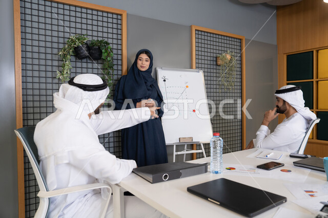 ضمان فهم واضح وشامل للاعمال باستخدام السبورة، مجموعة من الموظفين العرب الخليجيين الاماراتيين يعقدون اجتماع داخل مقر الشركة، تعلم اساليب العمل والتطوير المهني، العمل الجماعي وروح الفريق، التفاهم والتعاون بين الزملاء ووضع الخطط الاستراتيجية لتحقيق الأهداف