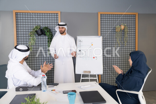 استخدام السبورة لضمان فهم واضح وشامل للاعمال، مجموعة من الموظفين العرب الخليجيين الاماراتيين يعقدون اجتماع داخل مقر الشركة، تعلم اساليب العمل والتطوير المهني، العمل الجماعي وروح الفريق، التفاهم والتعاون بين الزملاء ووضع الخطط الاستراتيجية لتحقيق الأهداف