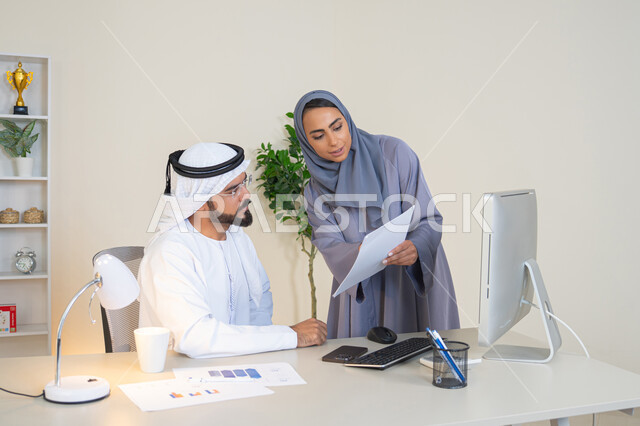 التعاون والتفاهم بين الزملاء ووضع الخطط الاستراتيجية، عقد اجتماع داخل مقر الشركة، موظفان عربيان خليجيان اماراتيان يتعلمان اساليب العمل والتطوير المهني، النقاش والتفاهم بين الموظفين، تبادل الخبرات والمعلومات لتحقيق الاهداف، روح الفريق الواحد والعمل الجماعي