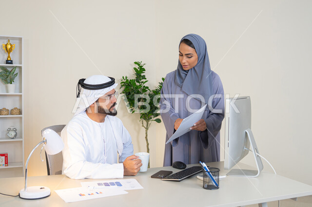 النقاش والتفاهم بين الموظفين، تبادل الخبرات والمعلومات لتحقيق الاهداف، روح الفريق الواحد والعمل الجماعي، التفاهم والتعاون بين الزملاء ووضع الخطط الاستراتيجية، عقد اجتماع داخل مقر الشركة، موظفان عربيان خليجيان اماراتيان يتعلمان اساليب العمل والتطوير المهني