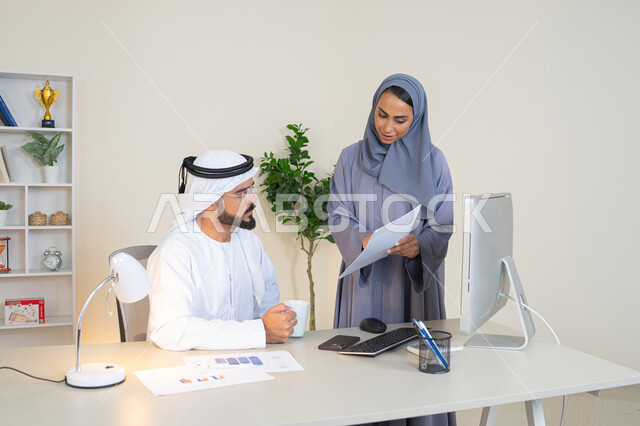 تبادل الخبرات والمعلومات لتحقيق الاهداف، روح الفريق الواحد والعمل الجماعي، التفاهم والتعاون بين الزملاء ووضع الخطط الاستراتيجية، عقد اجتماع داخل مقر الشركة، موظفان عربيان خليجيان اماراتيان يتعلمان اساليب العمل والتطوير المهني، النقاش والتفاهم بين الموظفين
