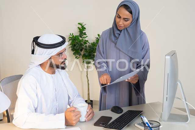 التعاون والتفاهم بين الزملاء ووضع الخطط الاستراتيجية، عقد اجتماع داخل مقر الشركة، موظفان عربيان خليجيان اماراتيان يتعلمان اساليب العمل والتطوير المهني، النقاش والتفاهم بين الموظفين، تبادل الخبرات والمعلومات لتحقيق الاهداف، روح الفريق الواحد والعمل الجماعي