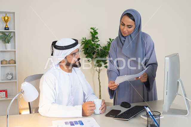 النقاش والتفاهم بين الموظفين، تبادل الخبرات والمعلومات لتحقيق الاهداف، روح الفريق الواحد والعمل الجماعي، التفاهم والتعاون بين الزملاء ووضع الخطط الاستراتيجية، عقد اجتماع داخل مقر الشركة، موظفان عربيان خليجيان اماراتيان يتعلمان اساليب العمل والتطوير المهني