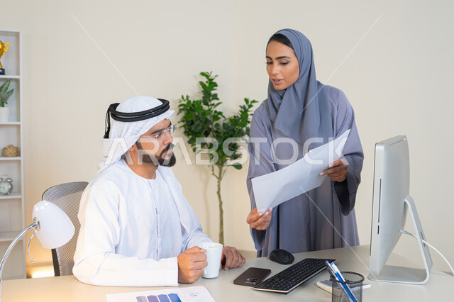 تبادل الخبرات والمعلومات لتحقيق الاهداف، روح الفريق الواحد والعمل الجماعي، التفاهم والتعاون بين الزملاء ووضع الخطط الاستراتيجية، عقد اجتماع داخل مقر الشركة، موظفان عربيان خليجيان اماراتيان يتعلمان اساليب العمل والتطوير المهني، النقاش والتفاهم بين الموظفين
