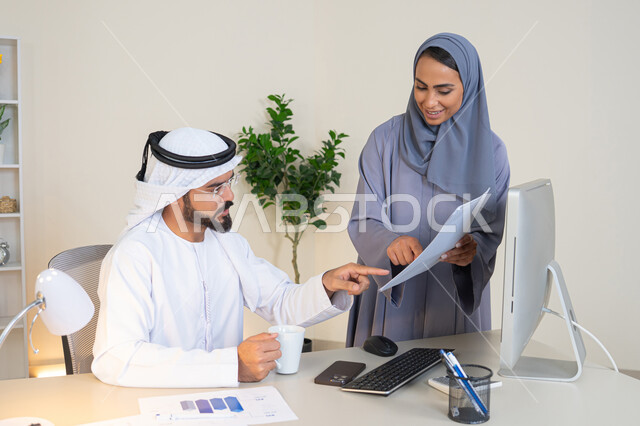 التعاون والتفاهم بين الزملاء ووضع الخطط الاستراتيجية، عقد اجتماع داخل مقر الشركة، موظفان عربيان خليجيان اماراتيان يتعلمان اساليب العمل والتطوير المهني، النقاش والتفاهم بين الموظفين، تبادل الخبرات والمعلومات لتحقيق الاهداف، روح الفريق الواحد والعمل الجماعي