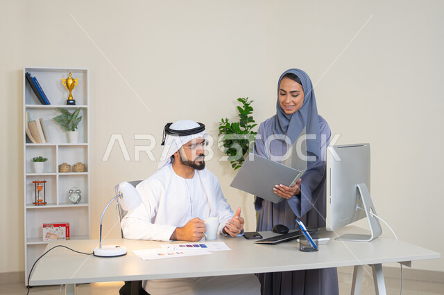 تبادل الخبرات والمعلومات لتحقيق الاهداف، روح الفريق الواحد والعمل الجماعي، التفاهم والتعاون بين الزملاء ووضع الخطط الاستراتيجية، عقد اجتماع داخل مقر الشركة، موظفان عربيان خليجيان اماراتيان يتعلمان اساليب العمل والتطوير المهني، النقاش والتفاهم بين الموظفين