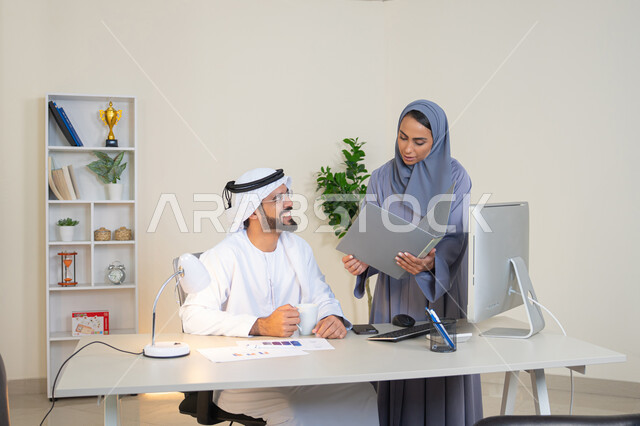 النقاش والتفاهم بين الموظفين، تبادل الخبرات والمعلومات لتحقيق الاهداف، روح الفريق الواحد والعمل الجماعي، التفاهم والتعاون بين الزملاء ووضع الخطط الاستراتيجية، عقد اجتماع داخل مقر الشركة، موظفان عربيان خليجيان اماراتيان يتعلمان اساليب العمل والتطوير المهني