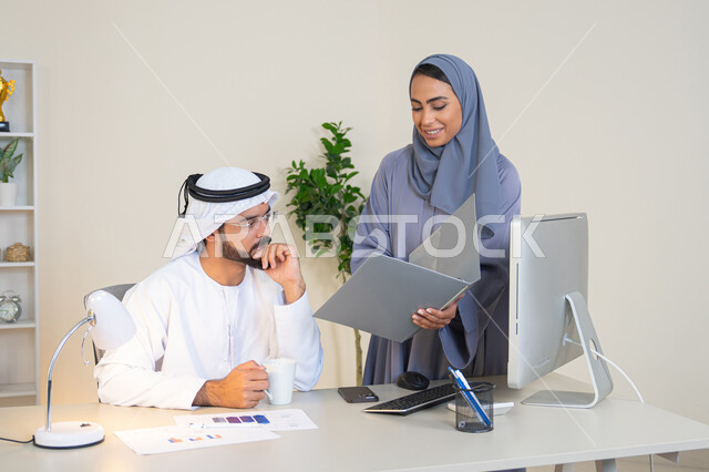 Exchange of experiences and information to achieve goals, team spirit and teamwork, understanding and cooperation among colleagues and developing strategic plans, holding a meeting at the company headquarters, two Arab Gulf Emirati employees learning work methods and professional development, discussion and understanding among employees