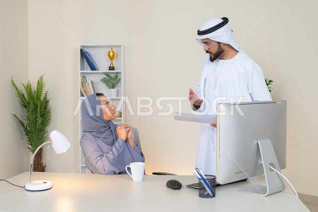 النقاش والتفاهم بين الموظفين، تبادل الخبرات والمعلومات لتحقيق الاهداف، روح الفريق الواحد والعمل الجماعي، التعاون بين الزملاء ووضع الخطط الاستراتيجية، عقد اجتماع داخل مقر الشركة، موظفان عربيان خليجيان اماراتيان يتعلمان اساليب العمل والتطوير المهني