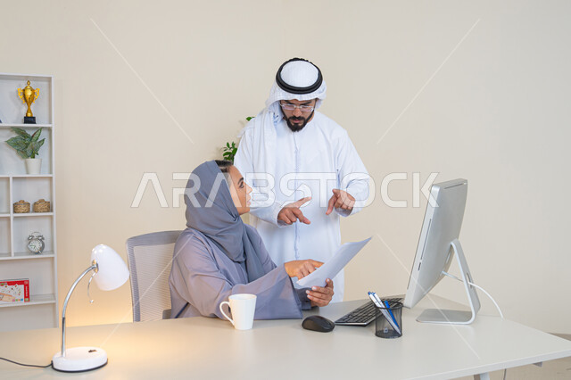 استخدام جهاز الحاسوب، التفاهم والتعاون بين الزملاء ووضع الخطط الاستراتيجية، عقد اجتماع داخل مقر الشركة، موظفان عربيان خليجيان اماراتيان يتعلمان اساليب العمل والتطوير المهني،  تبادل الخبرات والمعلومات لتحقيق الاهداف، روح الفريق الواحد والعمل الجماعي