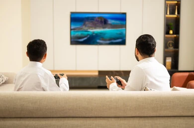 قضاء أوقات الفراغ مع العائلة، أب وإبن سعودي خليجي عربي بزي التقلدي يمسكان عصا التحكم و يلعبان بألعاب الفيديو، إيماءات تدل على الإندماج والتفاعل مع اللعبه، المتعة و التسلية بألعاب الفيديو، ألعاب البلايستيشن الترفيهية، اللعب مع الأطفال، مفهوم الأسرة السعيدة