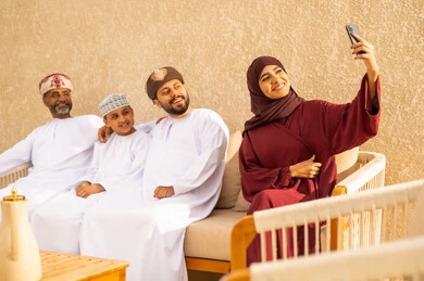 دمج التقنية الحديثة في توثيق اللحظات السعيدة، التقاط صورة سيلفي، زيارات الأهل والأقارب، منتجعات وشاليهات ترفيهية في عمان، عائلة عربية خليجية عمانية تقضي أوقات ممتعة في إحدى الشاليهات السياحية في السلطنة العمانية، فعاليات ترفيهية عائلية، عطلة صيفية