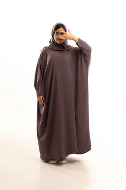 صحة العيون وفحوصات النظر الدورية، بورتريه لامرأة عربية خليجية سعودية محجبة ترتدي العباءة والنظارات الطبية تشير بعلامة تدل على اختبار الرؤية، الجسم بالطول الكامل، خلفية بيضاء