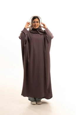 Using headphone techniques, the concept of listening and hearing, spending enjoyable and entertaining times, a side portrait of a Saudi Arabian Gulf woman wearing a hijab and abaya, wearing headphones, listening to music with gestures of happiness and joy, a full-body image, white background.