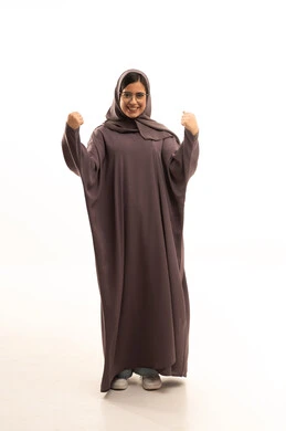 النجاح وتحقيق الأهداف، تعابير السرور والسعادة، بورتريه لامرأة عربية خليجية سعودية محجبة مبتسمة ترتدي العباءة تنظر إلى الكاميرا بايماءات وجه ويدين تدل على الفوز والإنتصار، الجسم بالطول الكامل، خلفية بيضاء
