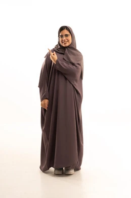 مفهوم الأناقة والاهتمام بالمظهر الخارجي، إشارات وحركات يدين تدل على هذا المكان (هنا)، تحديد موقع شيء معين،بورتريه لامراة عربية خليجية سعودية محجبة ترتدي العباءة و الحجاب تشير باصبع السبابة إلى الأعلى، الجسم بالطول الكامل، خلفية بيضاء