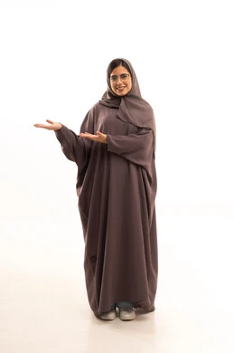 ايماءات التأكد من شيء ما ,التحديد نحو هدف معين, بورتريه لامرأة عربية خليجية سعودية مبتسمة ترتدي العباءة تشيربيديها نحو اتجاه واحد, الإشارة الى شخص ما, صورة الجسم بالطول الكامل, خلفية بيضاء
