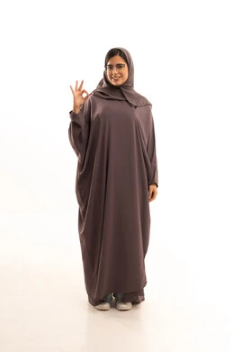 The concept of acceptance and approval, a sign of excellence and quality, a portrait of a smiling Saudi Gulf Arab woman wearing a hijab and abaya, raising her hand with gestures indicating admiration and satisfaction, full-body, white background.