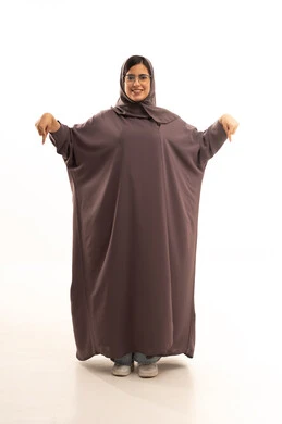 تحديد موقع معين، تعابير تحدد هذا المكان هنا،بورتريه لامراة عربية خليجية سعودية محجبة ترتدي العباءة و الحجاب و نظارة طبية  تشير بإصبع السبابة إلى الاسفل ، النظر إلى الكاميرا بإيماءات الفرح والسرور، الجسم بالطول الكامل، خلفية بيضاء