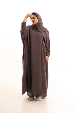 استحضار فوري لشيء ضروري، بورتريه لامراة عربية خليجية سعودية محجبة ترتدي العباءة و الحجاب و نظارة طبية تضع يدها على رأسها بايماءات تدل على النسيان، الجسم بالطول الكامل، خلفية بيضاء