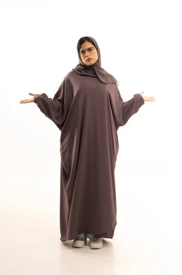 الشعور بالحيرة والجهل بأمر ما، التردد وانعدام المعرفة بخصوص شيء معين، بورتريه لامراة عربية خليجية سعودية محجبة ترتدي العباءة و الحجاب و نظارة طبية ترفع يديها بإيماءات عدم التأكد، صورة الجسم بالطول الكامل، خلفية بيضاء