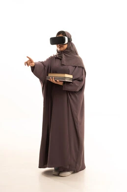 Integrating modern technologies with learning and training, referring to something, simulating the imaginary world, education using virtual reality technology, a portrait of a veiled Arab Gulf Saudi student wearing an abaya and hijab, wearing 3D VR glasses, holding a collection of books, full-body image, white background.
