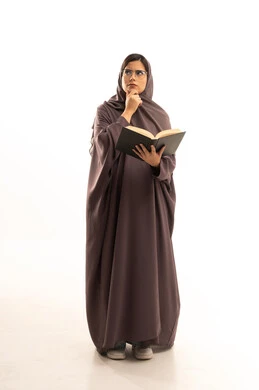 Reflection, focus, and planning for the future, reviewing daily lessons, the concept of diligence and excellence, higher education in the Kingdom of Saudi Arabia, a portrait of a Gulf Arab Saudi female student wearing an abaya holding a book in her hands, resting her hand on her chin and looking away in thought and contemplation, full-body, white background.