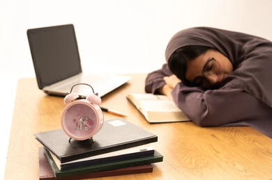 Fatigue and stress during studying, the importance of rest and good sleep in enhancing the mental and physical health of students, a portrait of a Saudi Arabian Gulf student wearing an abaya taking a nap while studying her lessons, studying late at night, black background. Fatigue and stress during studying, the importance of rest and good sleep in enhancing the mental and physical health of students, a portrait of a Saudi Arabian Gulf student wearing an abaya taking a nap while studying her lessons, studying late at night, black background.