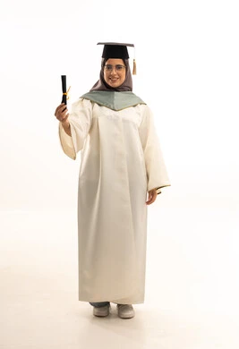 A university occasion and celebration, education in the Kingdom of Saudi Arabia, celebrating the completion of university studies, a portrait of a smiling, veiled Arab Gulf Saudi graduate wearing an abaya and cap, holding her graduation certificate in her hand, full-body length, white background.