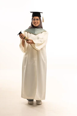 الوصول لحلم النجاح، الاحتفال بإنهاء الدراسة الجامعية, بورتريه لخريجة عربية خليجية سعودية محجبة مبتسمة ترتدي العباءة والقبعة تمسك بيدها وثيقة التخرج، شابة سعودية تنظر الى الكاميرا بإيماءات السعادة، الجسم الكامل بالطول، خلفية بيضاء