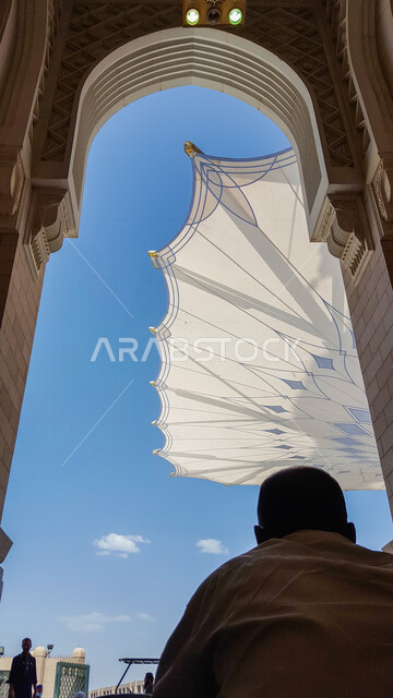 صورة لمسلمين داخل المسجد النبوي الشريف في المدينة المنورة بالمملكة العربية السعودية ، الحرم النبوي الشريف ، مسجد النبي محمد ، العبادة والتقرب إلى الله ، المعالم الأثرية الدينية ، المظلة الإلكترونية في المسجد النبوي الشريف في المدينة المنورة