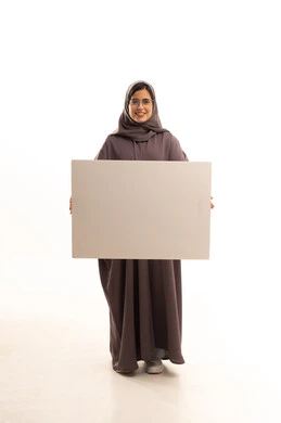 Marketing offers and advertisements, explanatory boards and educational tools, a portrait of a Saudi Gulf Arab woman wearing a hijab and abaya and glasses, holding a blank rectangular white board in her hands, looking at the camera with expressions of happiness and joy, a rectangular white mockup, full body, white background.