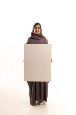 Illustrative boards and educational tools, marketing presentations and advertisements, a portrait of a Saudi Gulf Arab woman wearing a hijab and abaya and glasses, holding a blank rectangular white board in her hands, looking at the camera with expressions of happiness and joy, a rectangular white mockup, full-body, white background.