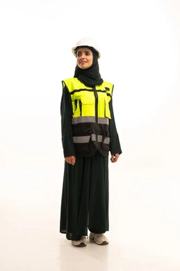 وظائف ومهن نسائية، النظر الى شيء ما ، مفهوم ادارة المشاريع الهندسية, الوقوف بايماءات الثقة, بورتريه لمهندسة عربية خليجية سعودية ترتدي خوذة وسترة الحماية تقف باستقامة، صورة لكامل الجسم، خلفية بيضاء