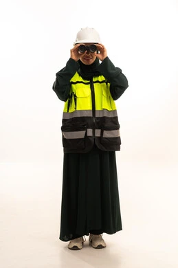 متابعة سير المشاريع الهندسية، مهن ووظائف نسائية، رؤية الأشياء البعيدة، بورتريه لمهندسة عربية خليجية سعودية ترتدي العباءة والخوذة وسترة الحماية  تنظر من خلال المنظار ثنائي العينين، الجسم باطول الكامل، خلفية بيضاء