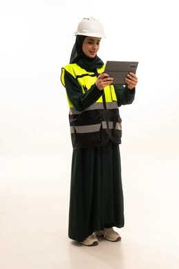 Study the fundamentals of the project through tablet applications, professions and jobs for Saudi women, adopting modern technologies and techniques in engineering, a portrait of a Saudi Gulf Arab industrial engineer wearing a vest and safety helmet monitoring the factory operations using a tablet, full-body, white background.