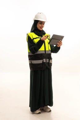 تحقيق الثورة الصناعية وكفاءة الإنتاج و التصنيع، اعتماد التقنيات والتكنولوجيا الحديثة في الهندسة, بورترية لمهندسة صناعية عربية سعودية خليجية ترتدي سترة وخوذة الحماية تتابع سير أعمال المصنع بإستخدام جهاز التابلت، مهن ووظائف سعودية نسائية، الجسم بالطول الكامل، خلفية بيضاء