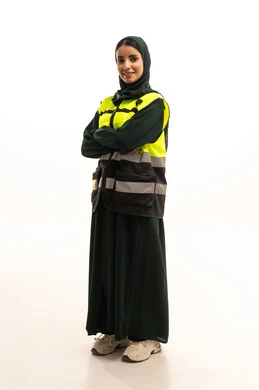 Women's jobs and professions, engineering project management, a portrait of an Arab Gulf Saudi female architect wearing an abaya and a safety vest standing with crossed arms, working in the engineering sector, full-body image, white background.