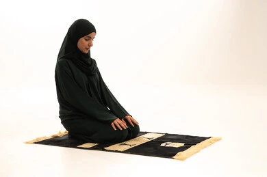 التضرع والخشوع أثناء الصلاة، الطاعة والعبادة والتقرب إلى الله عن طريق القيام بالعبادات، بورترية لإمرأة عربية خليجية سعودية تجلس على السجادة تقوم بأداء الفرائض ، إصلاح النفس بالتذلل لرب العالمين, اسلاميات وعبادة، خلفية بيضاء