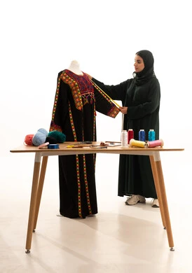 Fashion design workshop, portrait of a Gulf Arab Saudi fashion designer wearing a hijab and a black abaya, taking measurements using a measuring tape, concept of the fashion and style world, white background. Fashion design workshop, portrait of a Gulf Arab Saudi fashion designer wearing a hijab and a black abaya, taking measurements using a measuring tape, concept of the fashion and style world, white background.