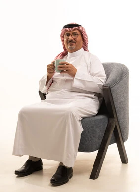 قضاء أوقات ممتعة في وقت الفراغ، شرب القهوة لتحسين المزاج، تناول المشروبات والأعشاب الساخنة في الشتاء، حسن الضيافة والاستقبال، بورتريه لرجل كبير مسن عربي سعودي خليجي يرتدي الثوب التقليدي والشماغ يمسك بيده كوب باللون الرمادي، خلفية بيضاء.