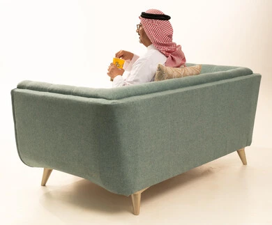 إحضار السناكات اللذيذة والاستعداد لمشاهدة الافلام، مشاهدة فلم سينمائي، بورتريه من الخلف لرجل عربي خليجي سعودي مبتسم كبير بالسن يرتدي الزي التقليدي و الشماغ يحمل بيده علبة الفوشار، إيماءات السعادة والمتعة، خلفية بيضاء