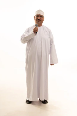 إلقاء المحاضرات وإقامة الندوات، الدورات التدريبية و ورشات العمل، تسجيل المقاطع الصوتية والغنائية،  تبادل الحوار والاستفادة من خبرات كبار السن، بورتريه لرجل عربي خليجي عماني يرتدي الدشداشة والعمامة يقف يحمل بيده مكبر الصوت، صورة الجسم بالطول الكامل، خلفية بيضاء