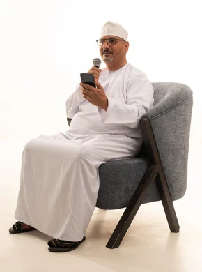 تقديم الفقرات الترفيهية والعروض الفنية المسرحية، المقابلات وطرح الأسئلة، القيام بالحوارات والنقاشات، القاء الخطابات والكلمات، بورتريه لرجل عربي خليجي عماني يرتدي الدشداشة والكمة يجلس على كرسي مريح يحمل بيده مكبر الصوت، خلفية بيضاء